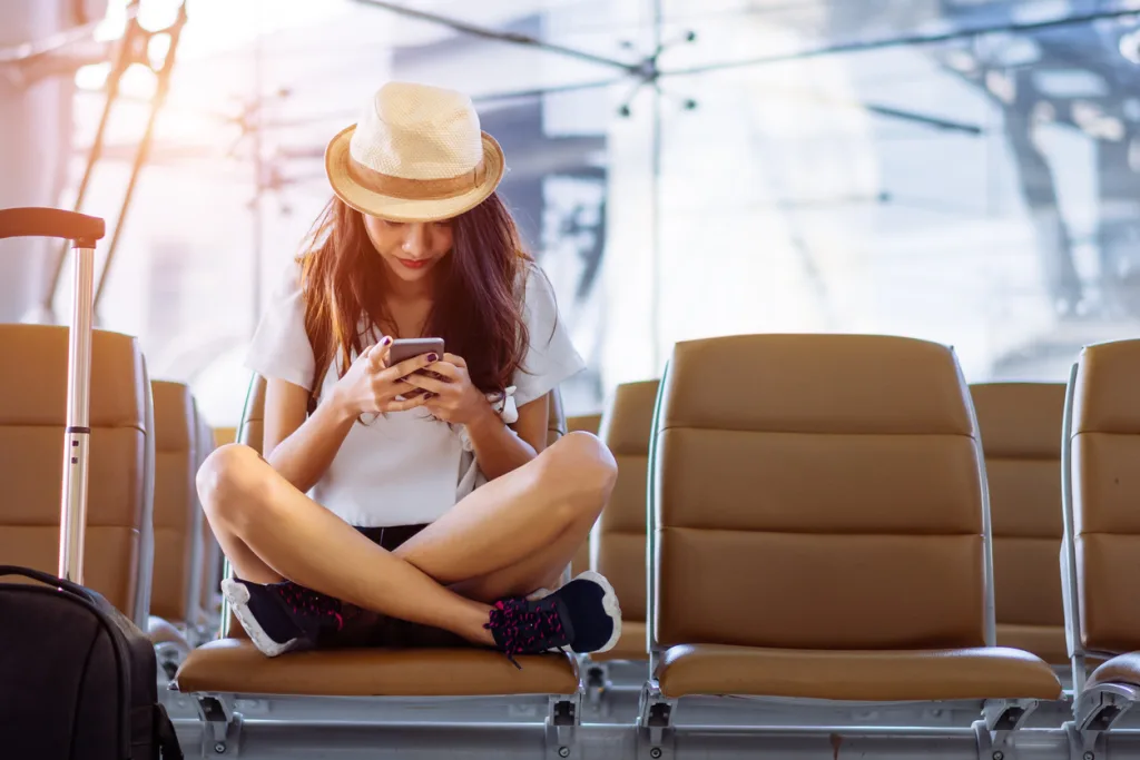 woman using smartphone while waiting for flight